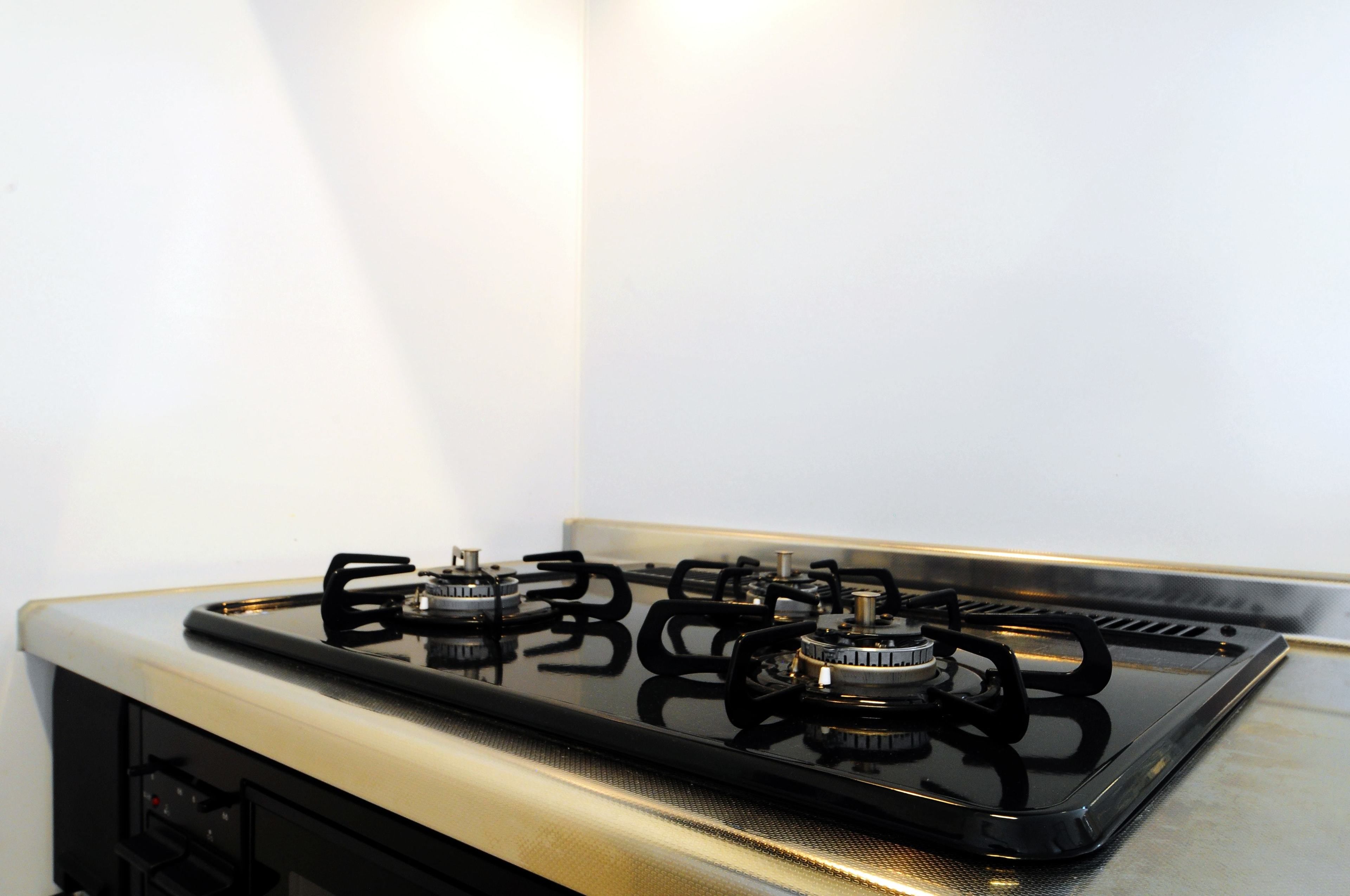A gas stove with four burners and a control panel.