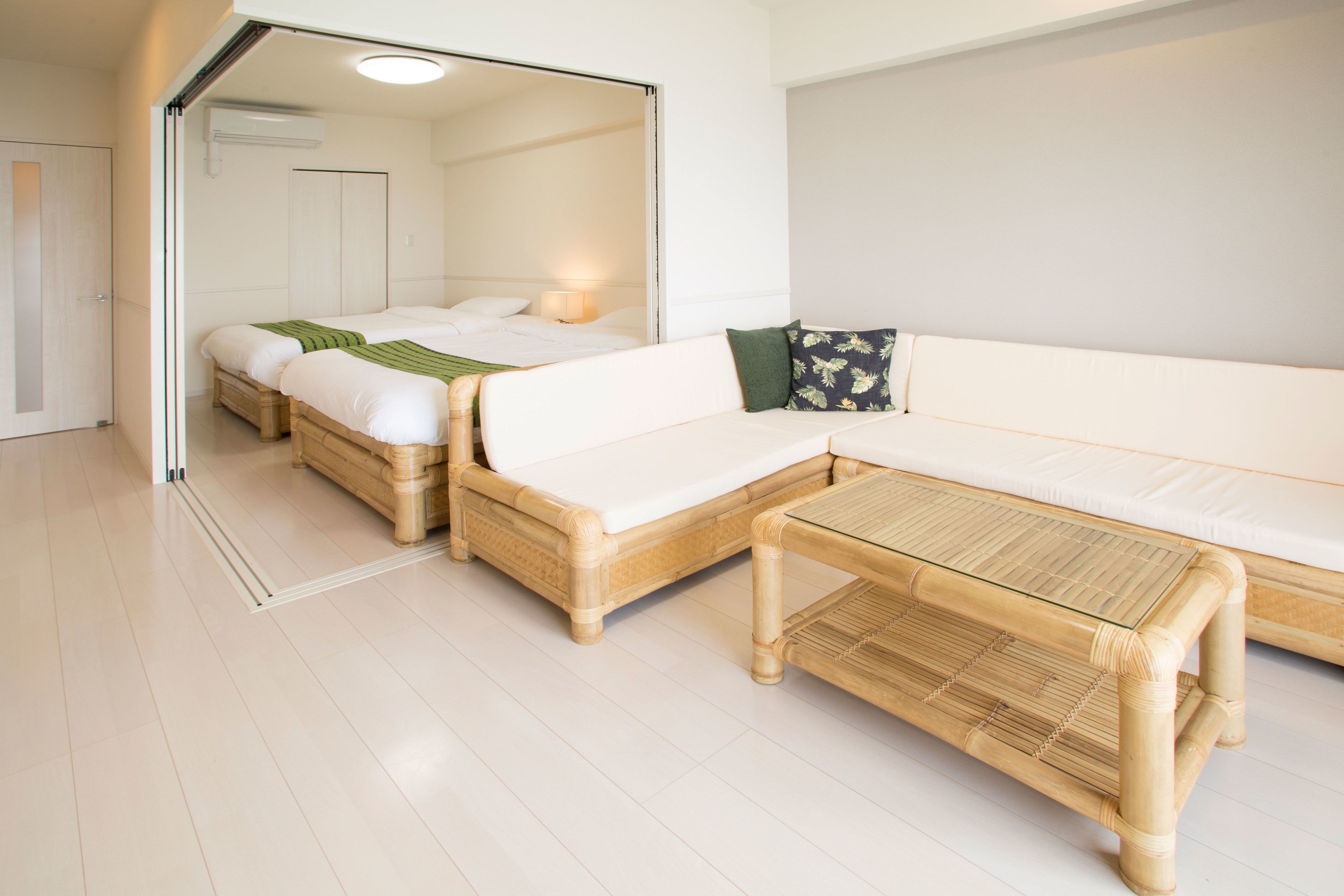 A modern hotel room with a large bed, a sofa, and a small table.