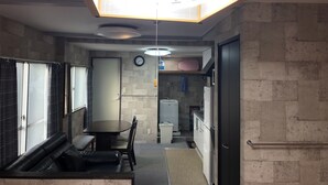 Una cocina compacta con comedor, un refrigerador empotrado y un reloj en la pared.
