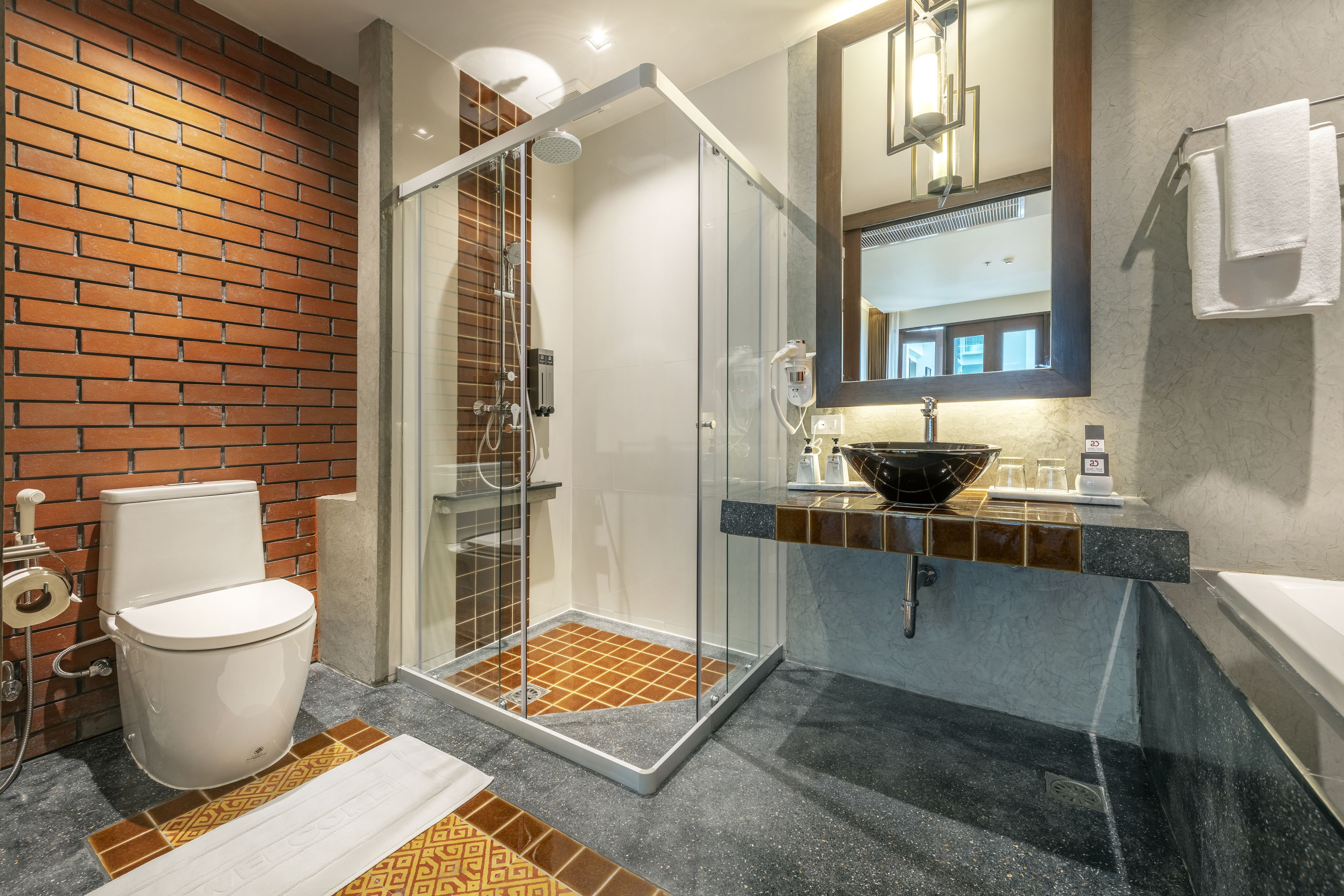 Une salle de bain moderne avec une douche à parois de verre, des toilettes blanches et un lavabo en marbre.