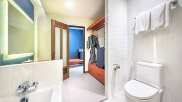 Un baño moderno con un inodoro blanco, un lavabo con grifo cromado y un espejo con marco iluminado.