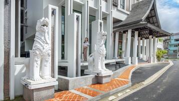 Un edificio con columnas blancas y un camino empedrado.