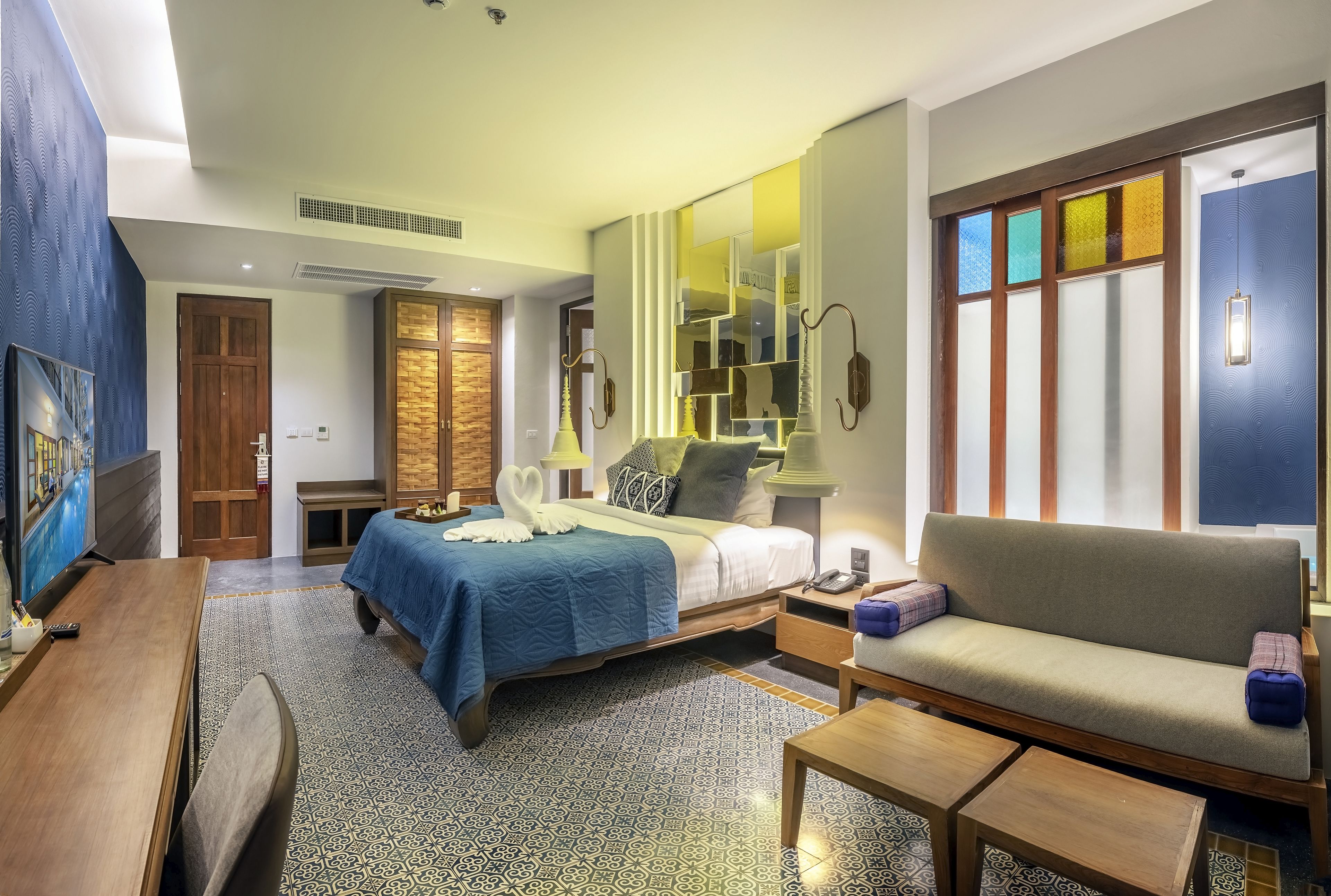 A hotel room with a bed, sofa, and a TV.