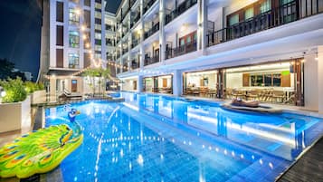 Una piscina al aire libre, sillones reclinables de piscina