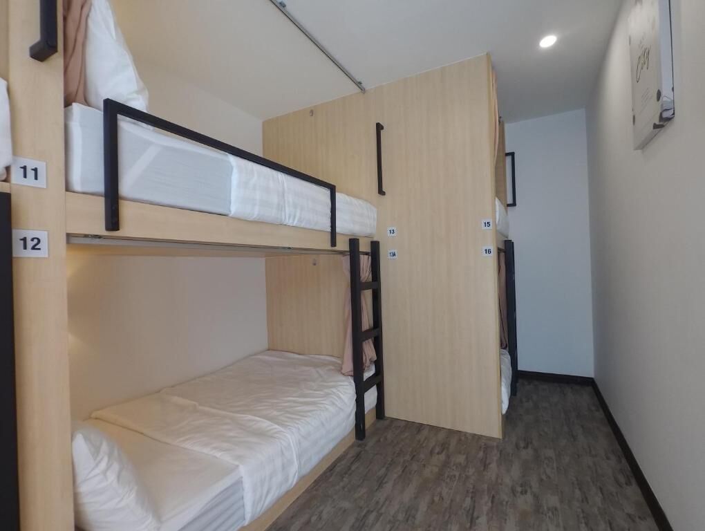 Habitación con literas de madera y un número en cada litera.