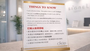 Ein Schild mit Informationen zu Hotel-Check-in-Zeiten, Zahlungsoptionen und Stornierungsbedingungen.