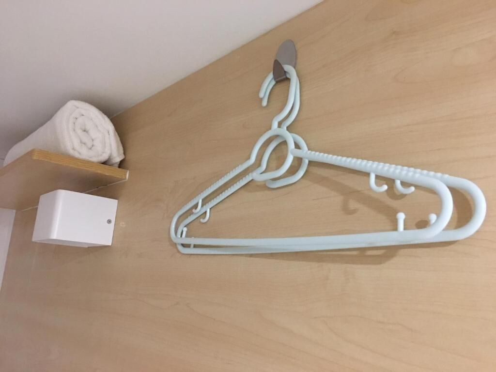 A white plastic hanger on a wooden surface.
