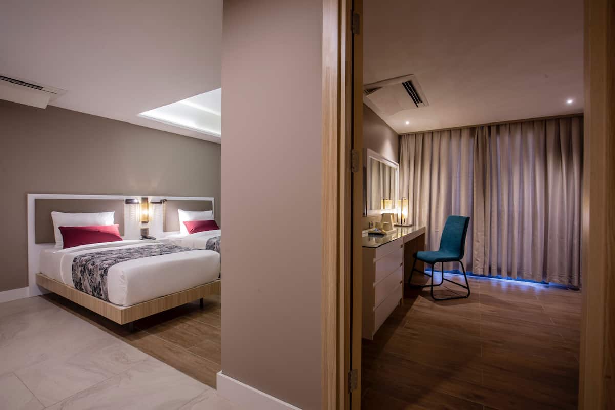 Une chambre d’hôtel avec un lit, une table de chevet, une chaise et une vue sur l’extérieur à travers les rideaux.