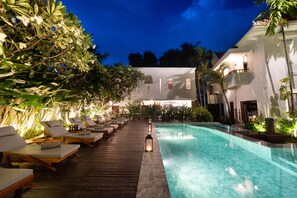 Alberca al aire libre, sombrillas en la alberca y camastros 