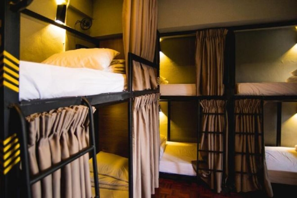 A bunk bed room with curtains and a shelf with towels.