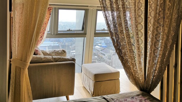 A bedroom with a bed, a window, and a view of the city. - Emma's home (Suzhou)