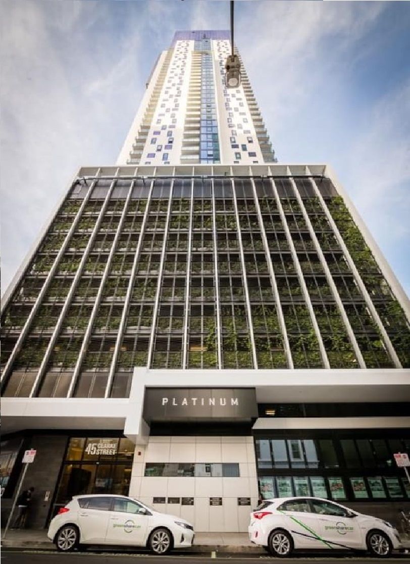 A tall building with a modern glass facade and a sign reading 'PLATINUM' at the base.
