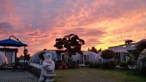 Un jardín con una estatua de oso, un pabellón y una hilera de edificios con forma de cúpula.