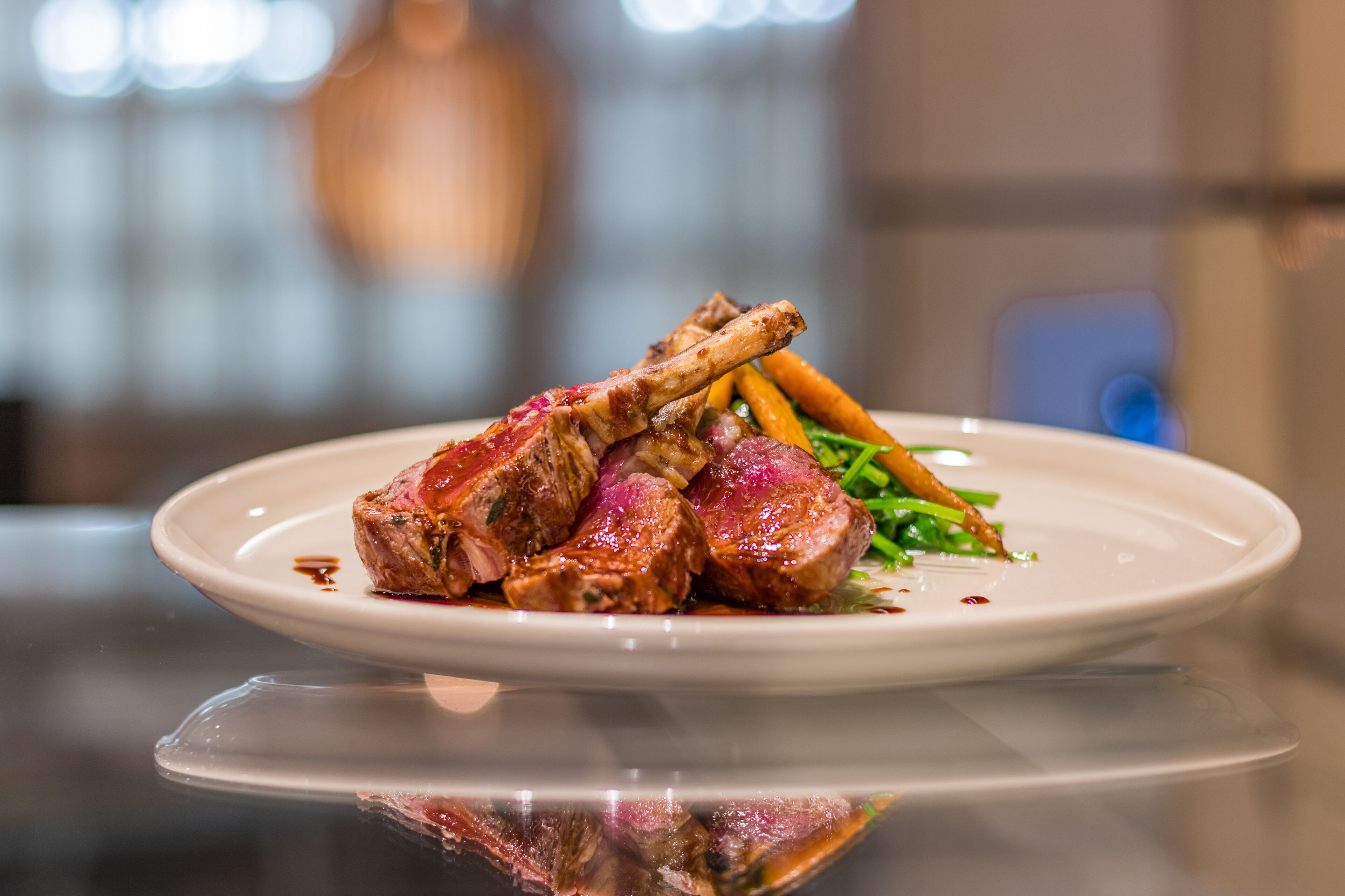 A plate of cooked meat with vegetables on a white plate.