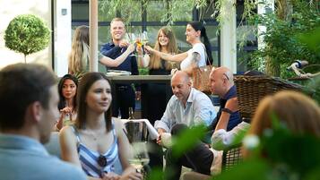 A group of people seated at an outdoor table, engaged in conversation.