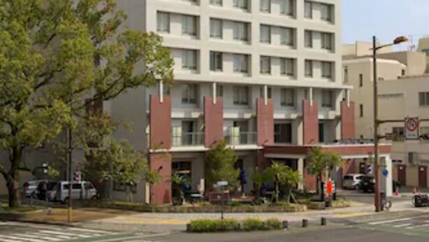 Un grand bâtiment rectangulaire abritant un hôtel, avec de nombreux étages et un toit plat.