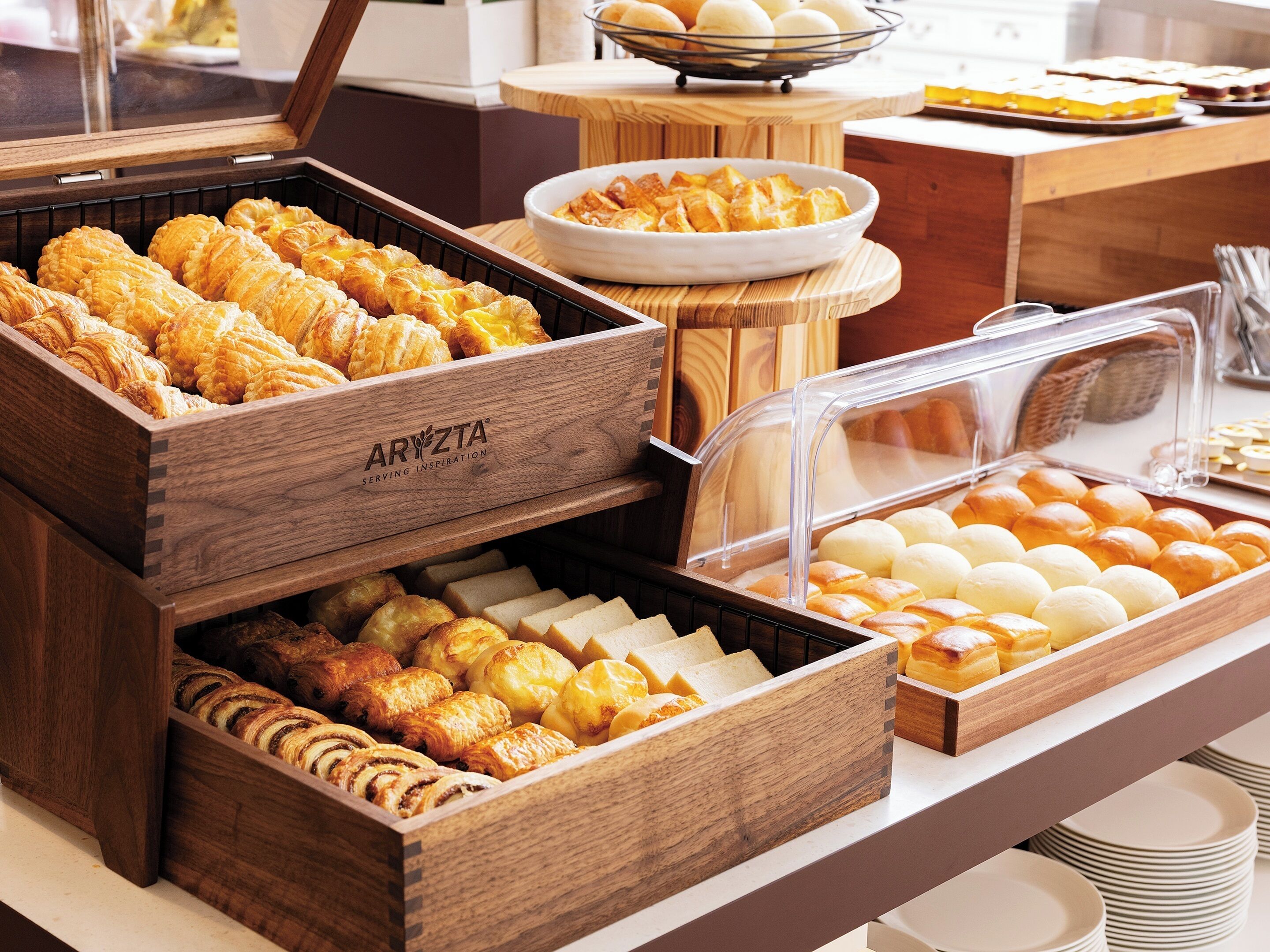 A buffet with various baked goods including pastries and bread.
