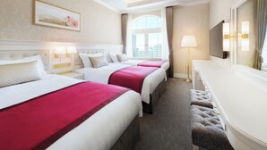 A hotel room with three beds, a large window, a TV, and a bench. - Takarazuka Hotel (Takarazuka)