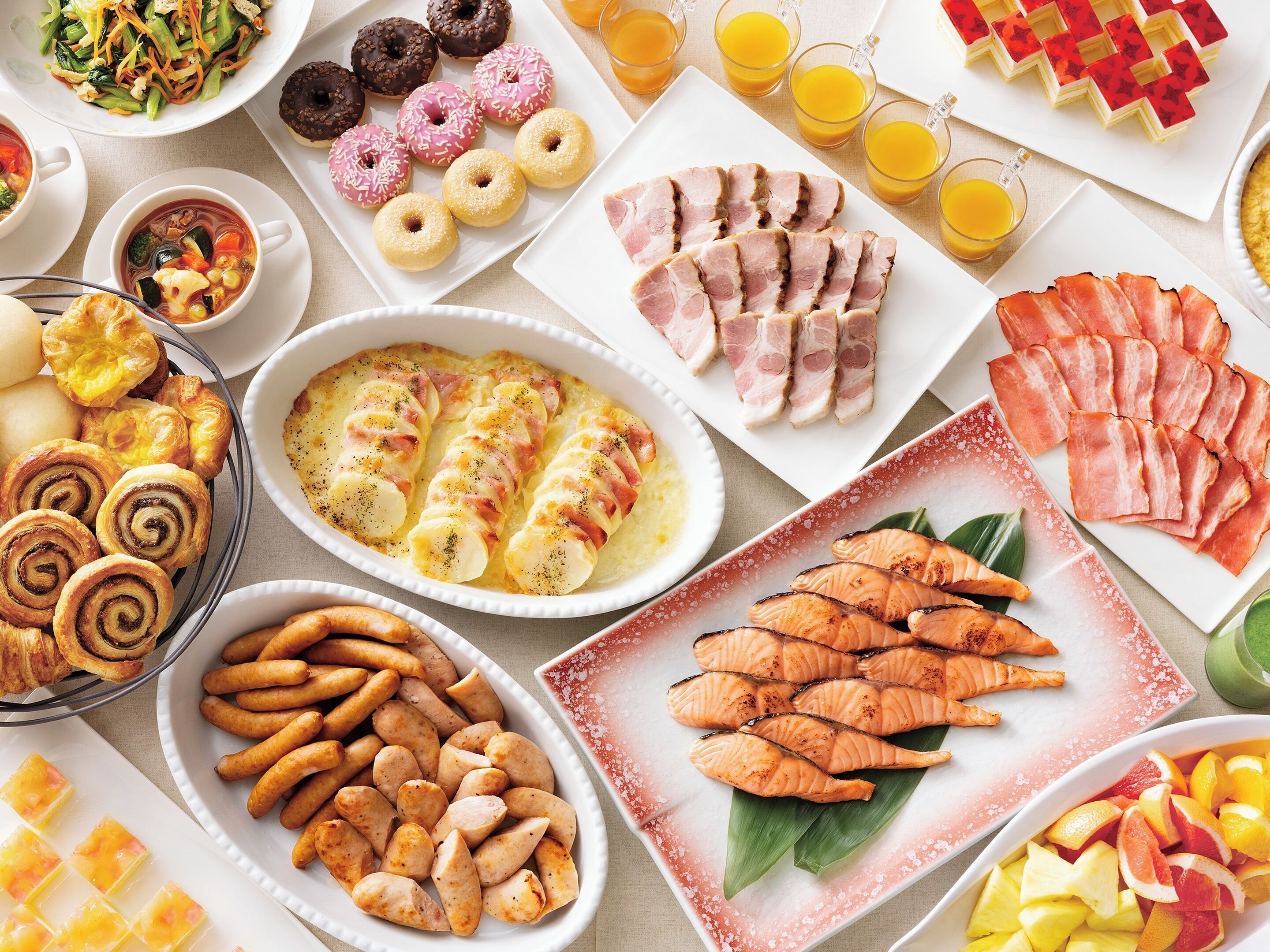 A variety of food items including pastries, smoked salmon, and grilled chicken.