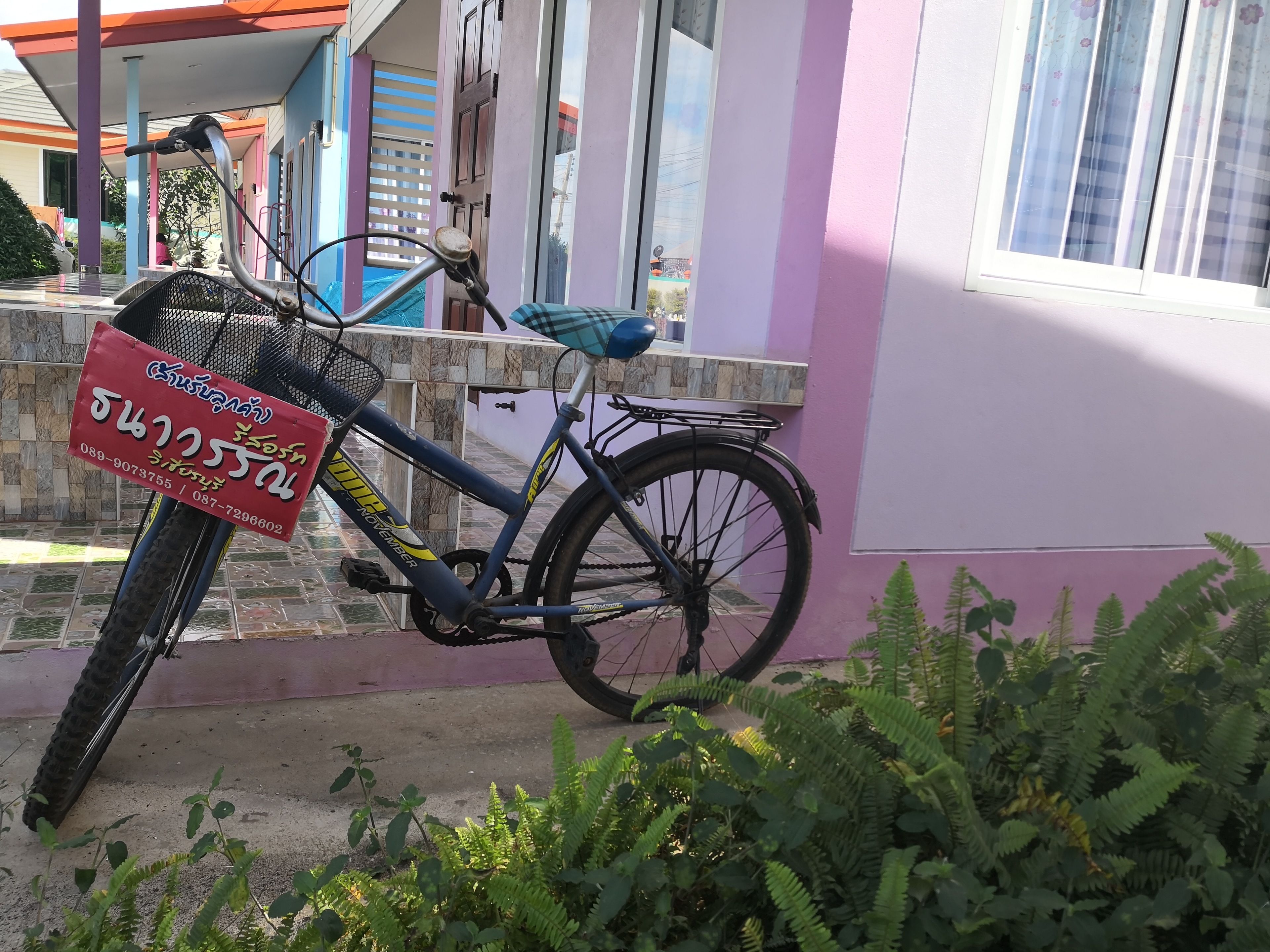 Una bicicleta estacionada frente a un edificio con un cartel.