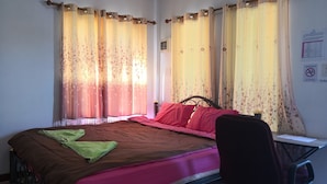 Un dormitorio con una cama, un escritorio y una silla.