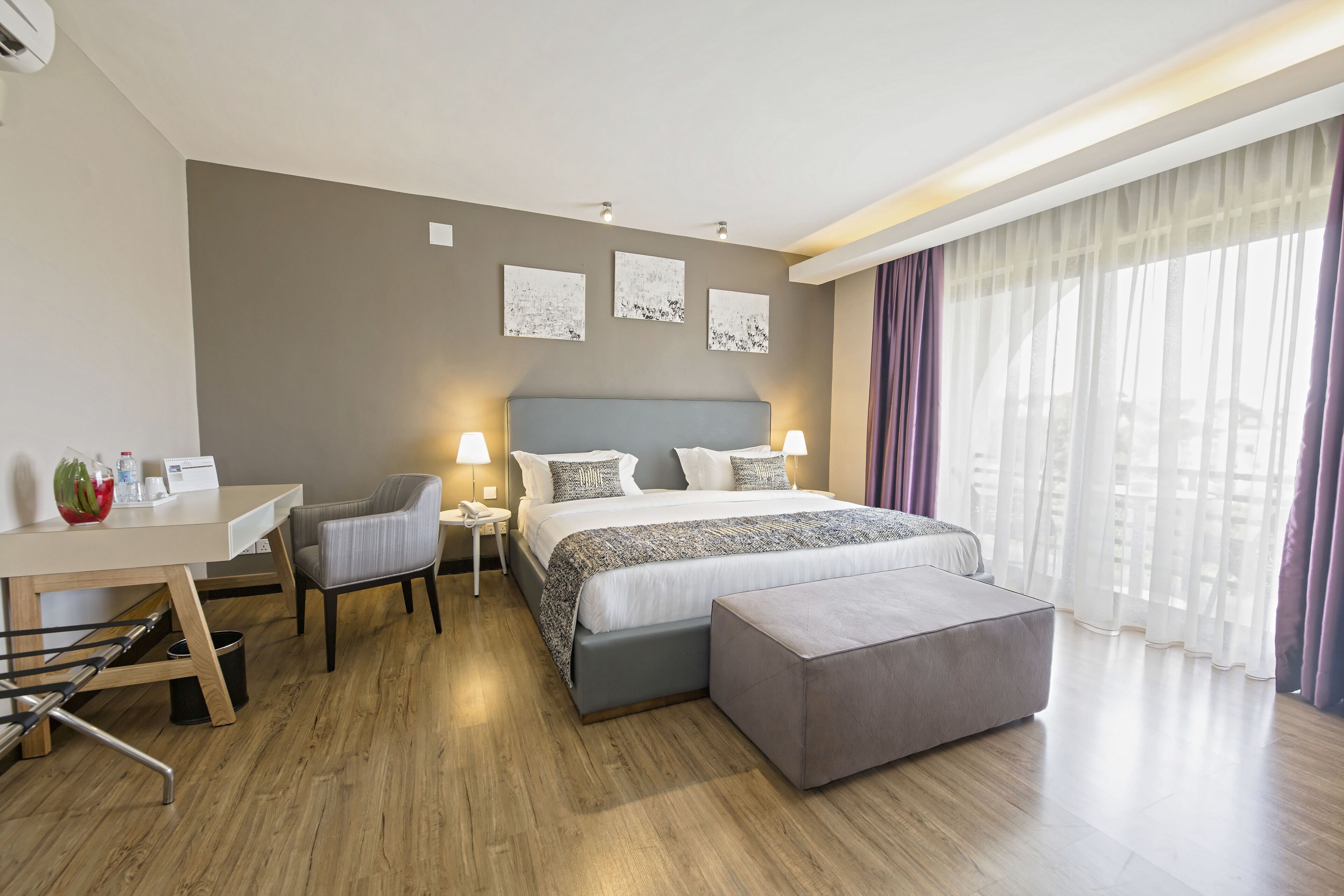 Una habitación de hotel moderna con una cama grande, un escritorio y una silla.