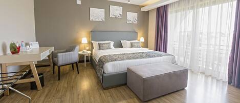 Una habitación de hotel moderna con una cama grande, un escritorio y una silla.