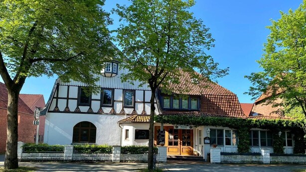 A traditional half-timbered building with a tiled roof, a small porch, and a sign that reads "Volmer." - Landgasthof Voltmer (Burgdorf)