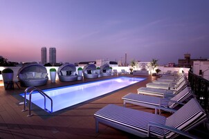 Una piscina al aire libre, sillones reclinables de piscina