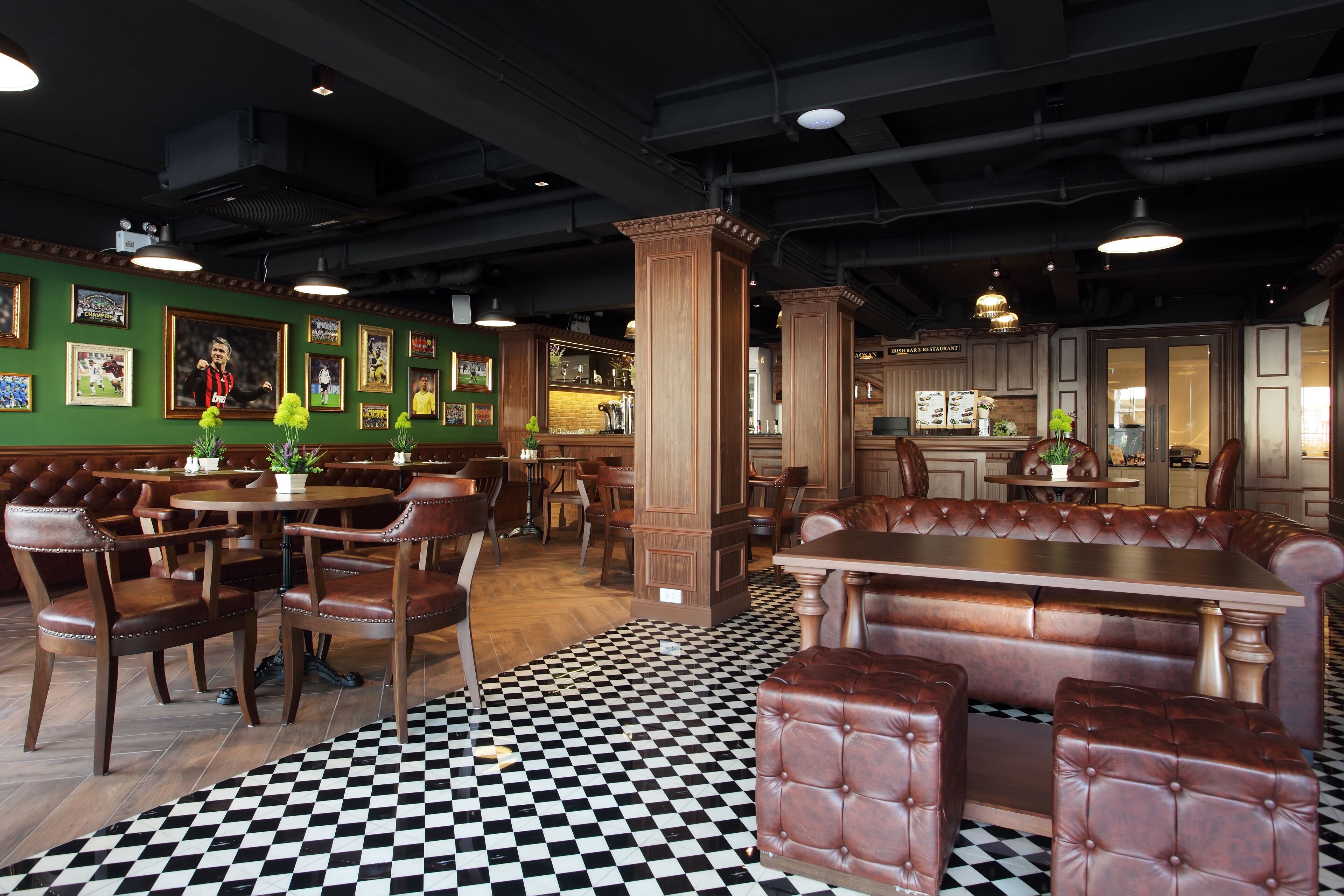 Un restaurante con suelo a cuadros, muebles de madera y cuadros en las paredes.