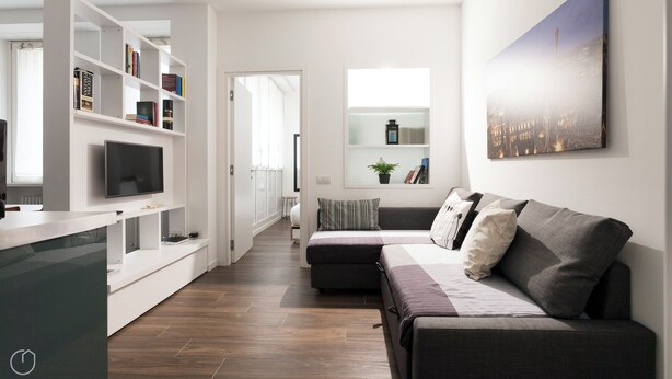 Een moderne woonkamer met een bank, een televisie en een boekenkast.