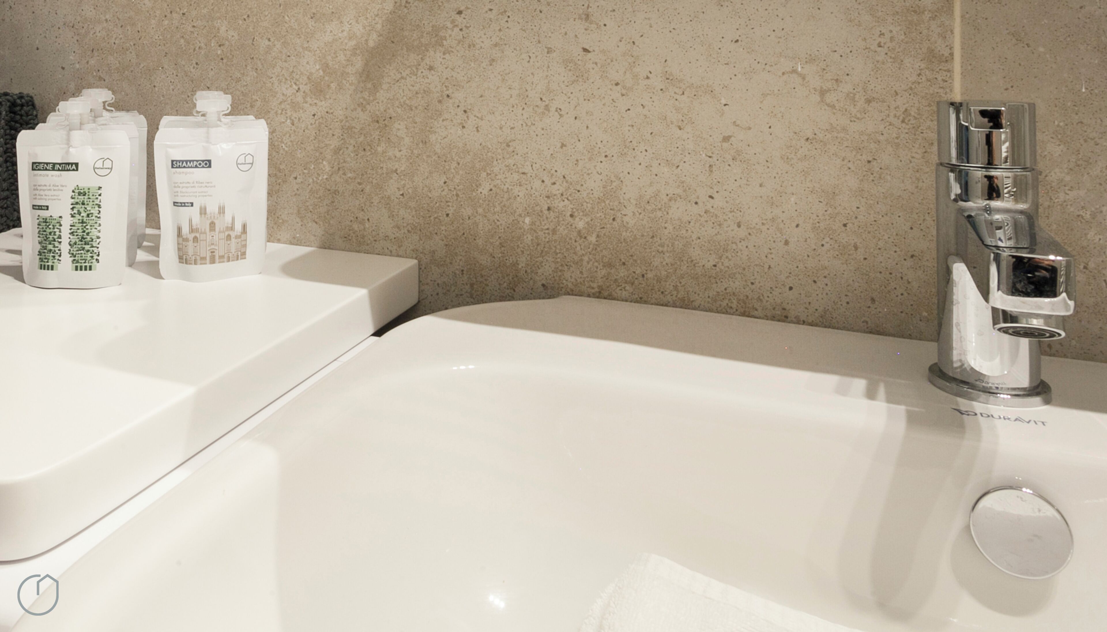A bathroom with a white bathtub, a modern faucet, and two bottles of shampoo and body wash on the counter.