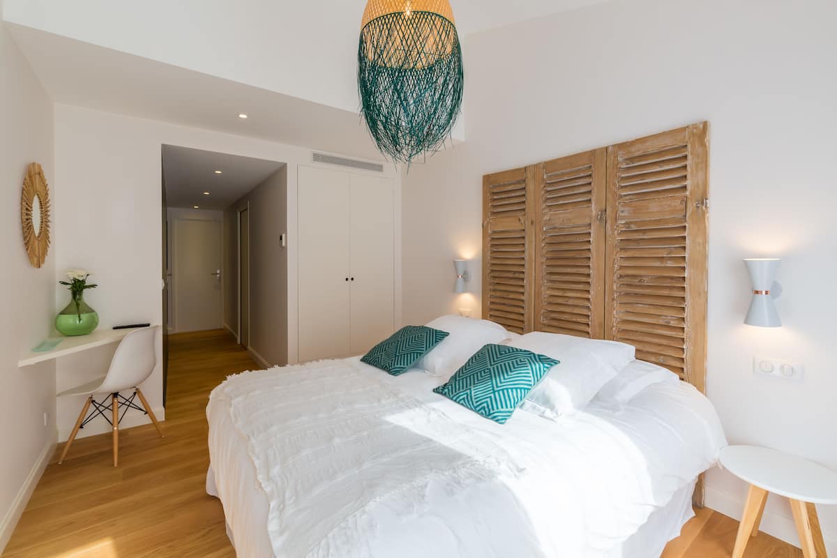 Un dormitorio con una cama grande, un escritorio y una silla.