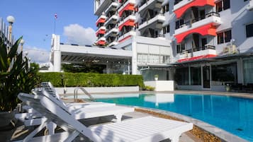 Una piscina al aire libre, sombrillas, tumbonas