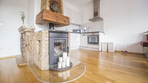 Une cuisine moderne avec une cheminée en pierre, des éléments décoratifs en bois et des appareils électroménagers en acier inoxydable.