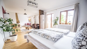 Une chambre d’hôtel moderne dotée d’un grand lit, d’un plancher en bois, d’un coin repas et offrant une vue sur la ville.
