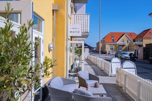 Un hotel con terraza al aire libre, balcón y vista despejada de la calle.