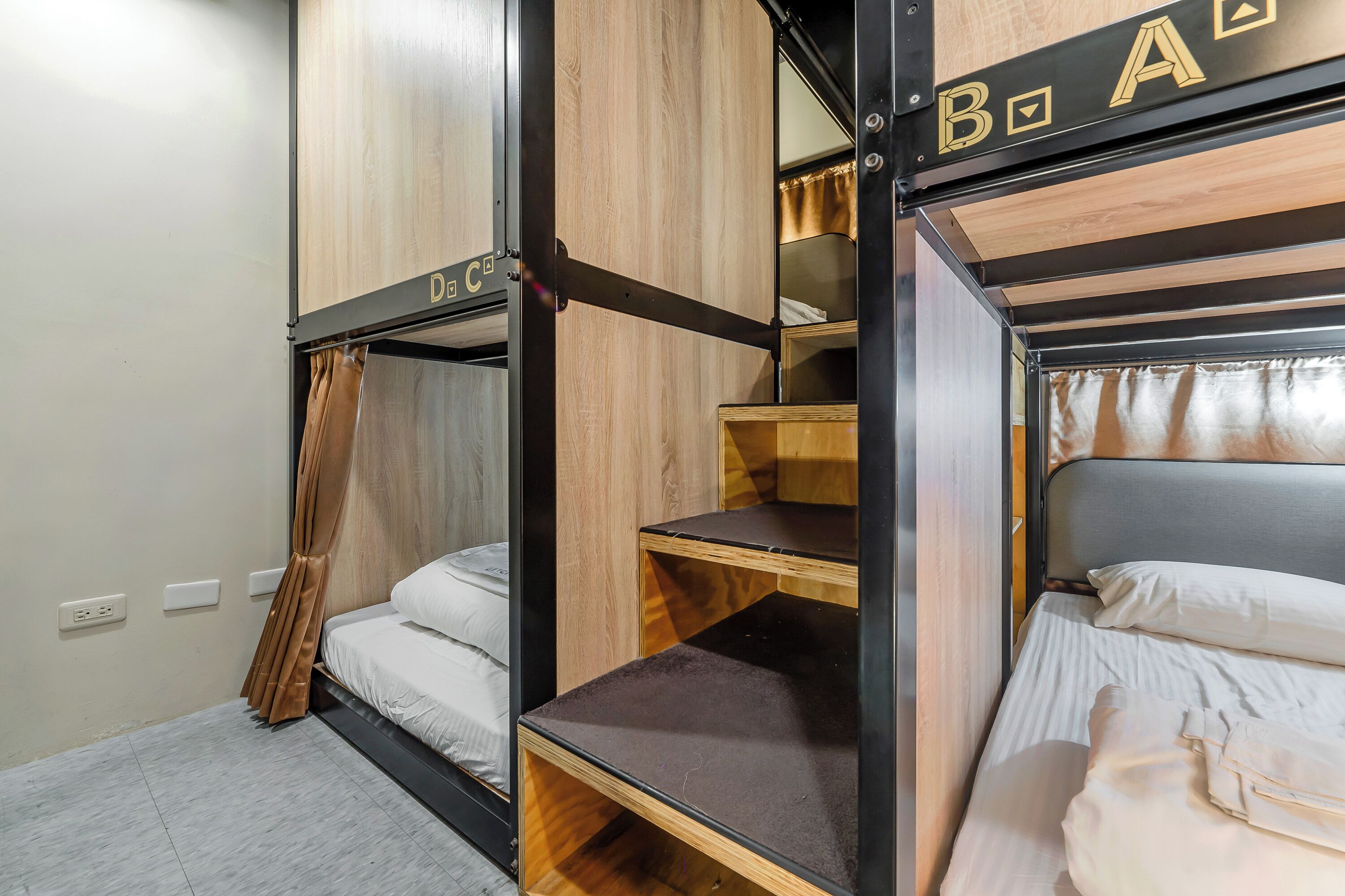 A bunk bed room with a wooden headboard, a small shelf, and a curtain.
