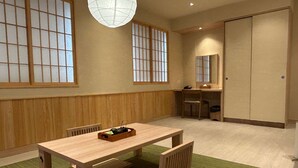 A traditional Japanese-style room with tatami flooring, a low wooden table with a tray, and sliding doors. - Kuretakeso Kemang Hotel (Jakarta)