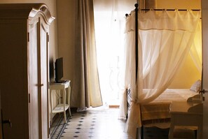 A bedroom with a bed, a TV on a small table, and a wardrobe. - B&B Garibaldi (Pisa)