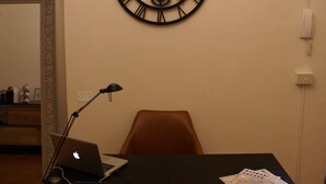 A room with a desk, chair, laptop, and a wall clock. - B&B Garibaldi (Pisa)