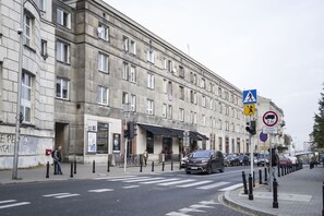 Ein historisches Gebäude mit einem großen Eingang, einer Fußgängerüberweg und einem Verbotsschild für Parken.