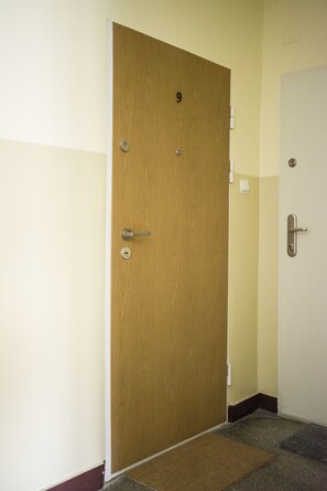 Une porte en bois portant le numéro 9, avec une poignée de porte et un sonnette.