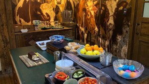 A buffet setup with various food items, including fruits, vegetables, and desserts.