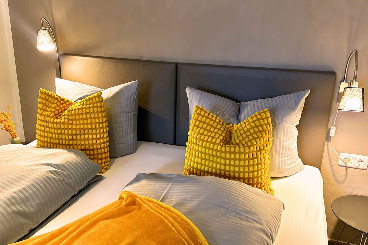A hotel room with two beds, each with a headboard, and a small table.