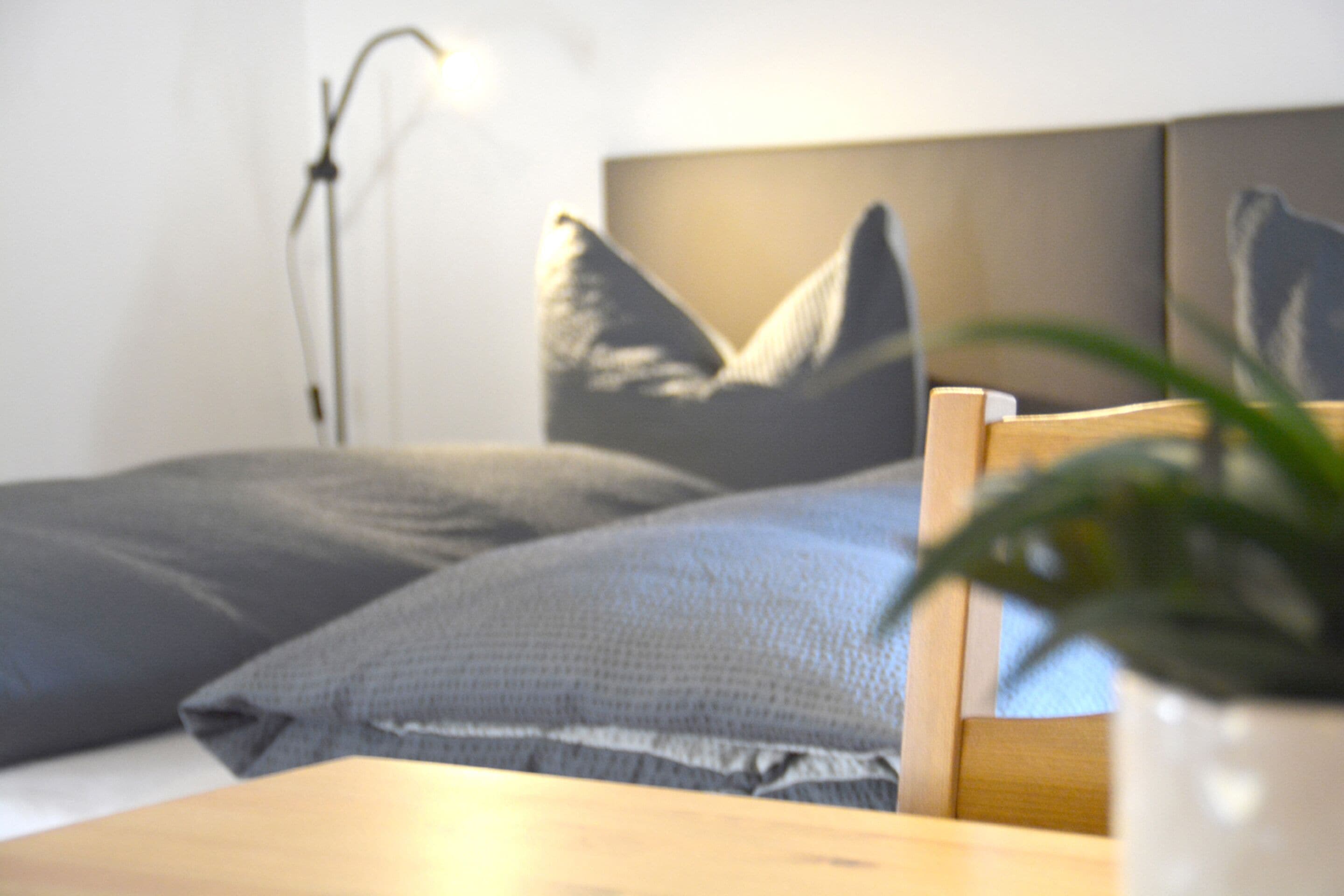 A bed with grey pillows and a wooden headboard.
