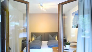 A bedroom with a bed, bedside tables, a ceiling fan, and a window.