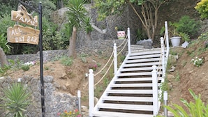 A wooden sign for 'Tango All Day Bar' with a white staircase leading up to it. - Tango Studios (Corfu)