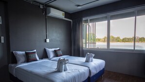 Habitació d'hotel amb dos llits, un finestra gran i vista exterior.