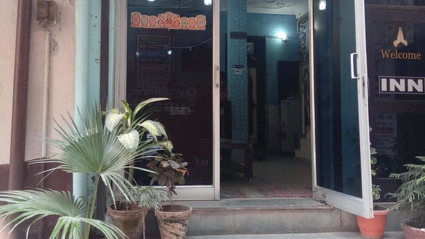 The entrance to Delhi Inn Guest House with a signboard, reception area, and potted plants. - Delhi Inn (New Delhi)
